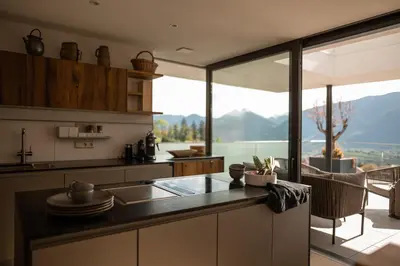 a kitchen with a counter with a view of the mountains at View House - Chalet Goyen in Schenna