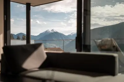 a couch in a room with a view of a mountain at View House - Chalet Goyen in Schenna