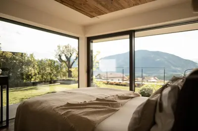 a bedroom with a bed and a large window at View House - Chalet Goyen in Schenna