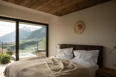 a bedroom with a bed and a large window at View House - Chalet Goyen in Schenna