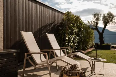 three chairs and a table on a patio at View House - Chalet Goyen in Schenna