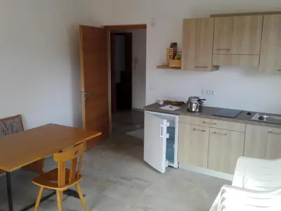 a kitchen with a wooden table and a kitchen with a table and chairs at Fewo Windbichl in Parcines