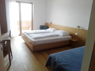 a bedroom with two beds and a large window at Fewo Windbichl in Parcines