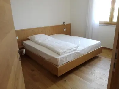 a bedroom with a bed with white sheets on it at Fewo Windbichl in Parcines