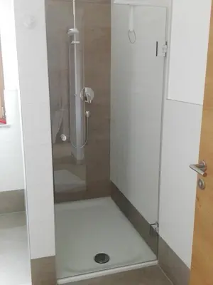 a shower with a glass door in a bathroom at Fewo Windbichl in Parcines