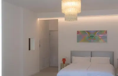 a bedroom with a bed and a chandelier at Emma Suite Merano in Merano