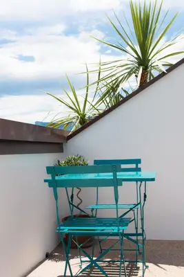 a blue table and a chair next to a wall at Emma Suite Merano in Merano