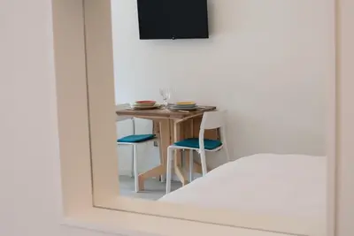 a table and chairs in a room with a mirror at Emma Suite Merano in Merano