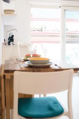 a dining room table with a chair with a green seat at Emma Suite Merano in Merano