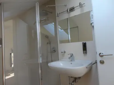 a bathroom with a sink and a shower and a mirror at Appartamento Riscone Nuvola di Plan in Brunico