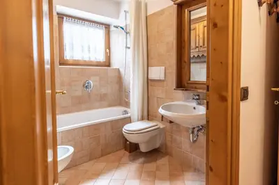a bathroom with a toilet and a sink and a tub at Casa Cristallo in Cortina dʼAmpezzo