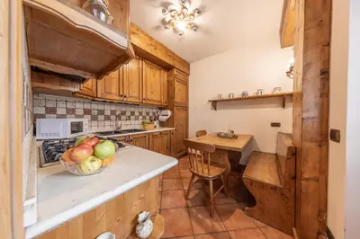 a kitchen with wooden cabinets and a bowl of fruit on a counter at Casa Cristallo in Cortina dʼAmpezzo