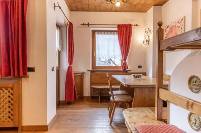 a dining room with red curtains and a table at Casa Cristallo in Cortina dʼAmpezzo
