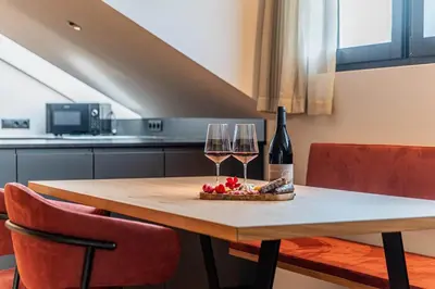 a table with two glasses of wine and a bowl of fruit at Kandlerhof in Bolzano