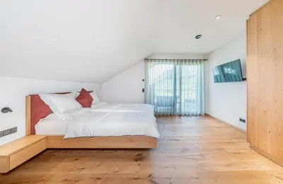 a bedroom with a bed and a large window at Kandlerhof in Bolzano