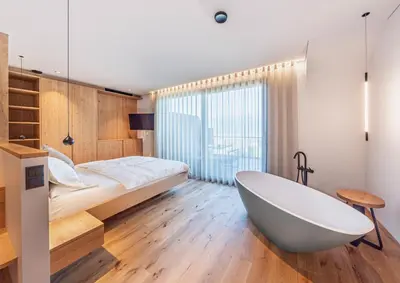 a bathroom with a bath tub and a bed at Kandlerhof in Bolzano