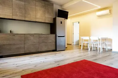 a kitchen with a refrigerator and a table with chairs at Roma Ariston 7 in Bolzano