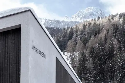 a building with a view of a snow covered mountain at Villa Margareth in Selva di Val Gardena