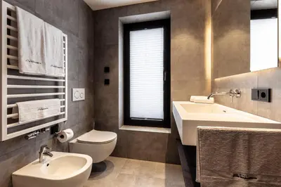 a bathroom with a sink and a toilet and a sink at Villa Margareth in Selva di Val Gardena