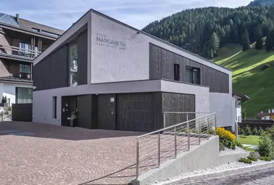a building with a sign on the side of it at Villa Margareth in Selva di Val Gardena