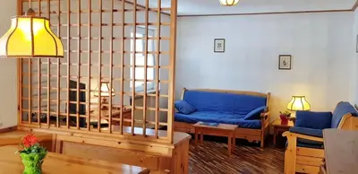 a living room with a blue couch and a table at CASA CAVALESE in Cavalese