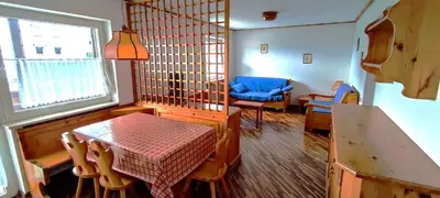 a living room with a table and a blue chair at CASA CAVALESE in Cavalese