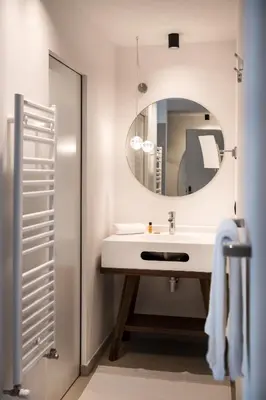a bathroom with a sink and a mirror at Hotel Ciasa Tamá in La Villa