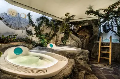 a bathroom with two sinks and a bath tub at Hotel Ciasa Tamá in La Villa