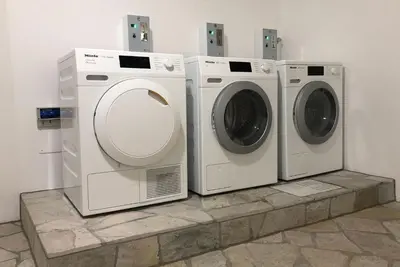 three washing machines and a dryer in a room at Apartments Griesser - Included BrixenCard and parking garage in house in Bressanone