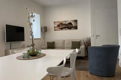 a white living room with a white table and chairs at Apartments Griesser - Included BrixenCard and parking garage in house in Bressanone