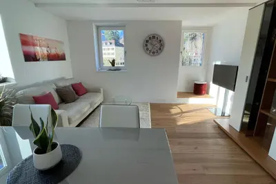 a living room with a white couch and a table at Apartments Griesser - Included BrixenCard and parking garage in house in Bressanone