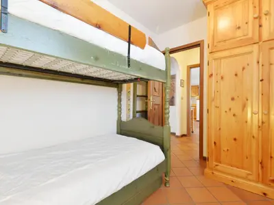 a bedroom with a wooden bed and a window at Apartment Casa Marmolada by Interhome in Penia