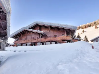 a snow covered road in front of a lodge at Apartment Casa Marmolada by Interhome in Penia