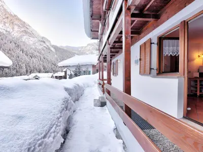 a house with a wooden facade with a porch at Apartment Casa Marmolada by Interhome in Penia