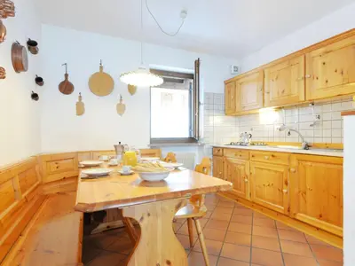 a kitchen and living room with a green couch at Apartment Casa Marmolada by Interhome in Penia
