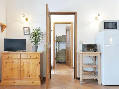 a kitchen with wooden cabinets and a wooden table at Apartment Casa Marmolada by Interhome in Penia
