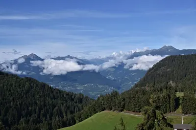 a view of a mountain valley with trees and clouds at Panoramaresidence Hafling in Avelengo