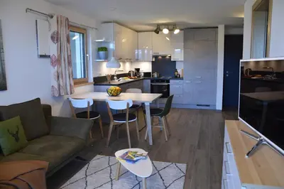 a living room and kitchen with a couch and a table at Panoramaresidence Hafling in Avelengo