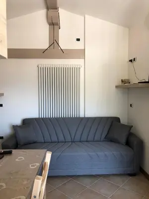 a blue couch in a living room with a table at Appartamento Primiero San Martino di Castrozza in Fiera di Primiero