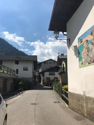 a street with a painting on the side of a building at Appartamento Primiero San Martino di Castrozza in Fiera di Primiero