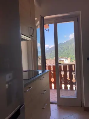 a kitchen with a view of a balcony at Appartamento Primiero San Martino di Castrozza in Fiera di Primiero