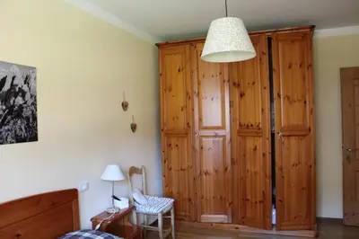 a bedroom with a large wooden closet and a chair at Apartment El Cor in Taibon
