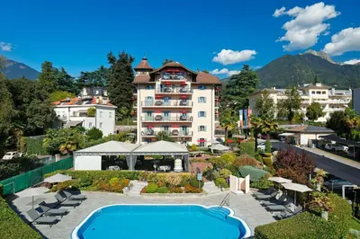 a hotel room with a bed and two chairs at Hapimag Apartments Meran in Merano