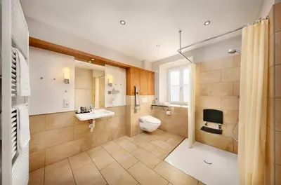 a bedroom with a bed with white sheets and wooden floors at Hapimag Apartments Meran in Merano