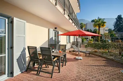 a patio with a table and chairs and an umbrella at Hapimag Apartments Meran in Merano