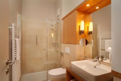 a bathroom with a shower and a sink and a toilet at Hapimag Apartments Meran in Merano