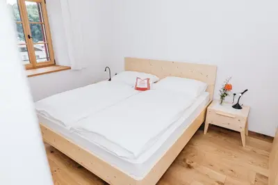 a bedroom with a large white bed and a window at Firmelein in Appiano sulla Strada del Vino