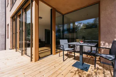 a patio with a table and chairs on a wooden deck at Firmelein in Appiano sulla Strada del Vino