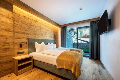 a bedroom with a bed and a large window at MULIN Appartements in Valles