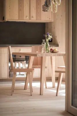 a wooden table with a vase of flowers on it at Larix Lodge in La Villa